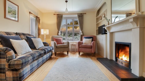 The sitting room with open fire at Old Church Lodge, Isle Of Wight
